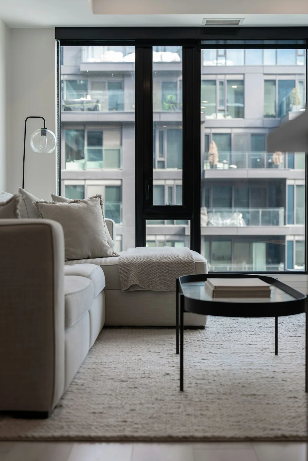 Un couple range son salon, en déplaçant meubles et tapis avec esprit d’équipe.
